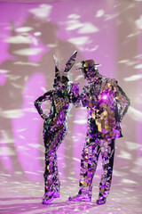 Obraz premium Mirror dancers performing under purple lights: rabbit and man dancing together
