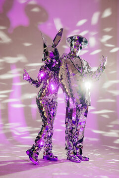 Fototapeta Mirror dancers performing in purple lights: entertainment and innovation