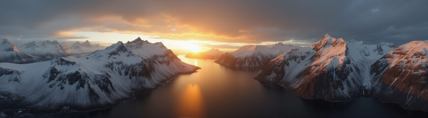 A beautiful northern landscape at sunset, with snow-covered mountains and a lake.
