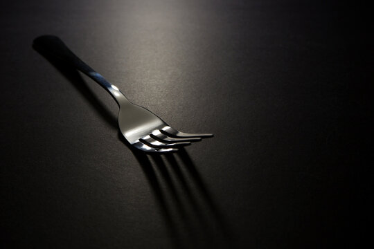 A fork isolated on black background closeup shot , Fork macro photography 