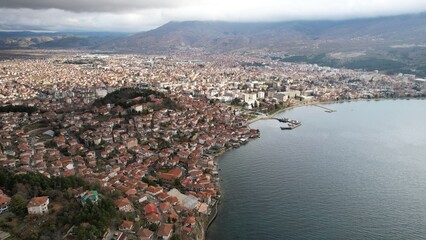 Fototapeta premium Historic Samuel's fortress overlooks serene coastal town with modern architecture under cloudy sky, Ohrid 
