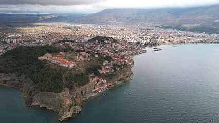 Historic Samuel's fortress overlooks serene coastal town with modern architecture under cloudy sky, Ohrid
