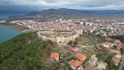 Obraz premium Historic Samuel's fortress overlooks serene coastal town with modern architecture under cloudy sky, Ohrid 