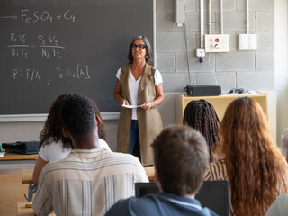 Female Teacher Teaching Math and Science to Diverse Teen Students in Classroom