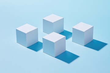 Obraz premium Four white cubes arranged on a light blue surface, casting distinct shadows