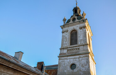 View of a tall historic bell tower of St. George's Cathedral in Lviv with architectural details against a vivid blue sky, evoking a sense of history, culture, and architectural beauty