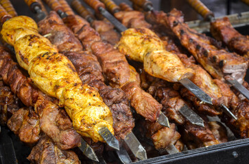 Grilled meat skewers cooking over an open flame, showcasing flavorful marination and smoky char
