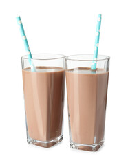 Tasty chocolate milk and straws in glasses isolated on white