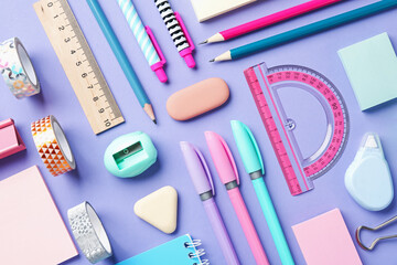 Pens and other stationery on violet background, flat lay