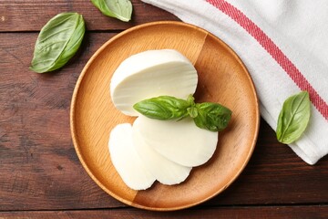 Tasty mozzarella and basil on wooden table, flat lay