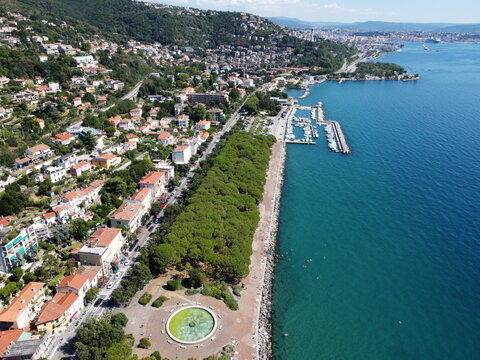 A stunning drone view of Trieste from Barcola, showcasing the city's coastline, historic buildings, and Adriatic charm under a clear northern Italian sky.