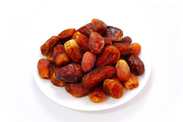 A full plate of dates fruits closeup shot  on white background 