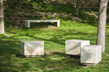 Quiet urban park with minimalist concrete seating surrounded by lush greenery and trees