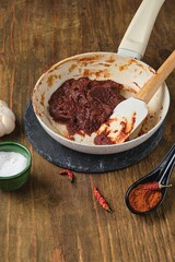 Step by step cooking of gochujang pepper paste at home on dark wooden background. Korean cuisine.