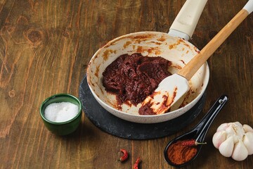 Step by step cooking of gochujang pepper paste at home on dark wooden background. Korean cuisine.
