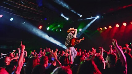 Country music artist performs on stage in front of excited crowd during live concert at outdoor venue - Powered by Adobe