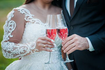 Romantic Wedding Toast: Bride and Groom Celebrating with Champagne Glasses in a Lush Outdoor Setting, Warm Lighting.