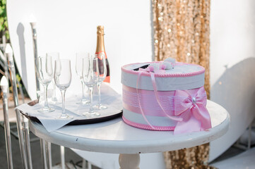 Elegant Wedding Gift Box with Champagne, Glasses, and Celebration Setup: Pink, Gold, and White.