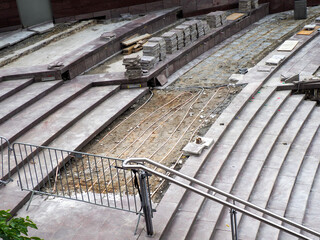 Diagonal concrete stairs with metal handrail creating geometric architectural pattern in urban...