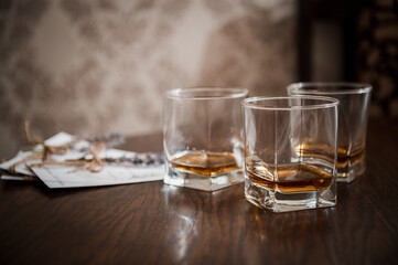 Three Glasses of Whiskey on a Dark Wood Table with Lavender and Reflections, Moody Bar Scene, Rich Amber Tone