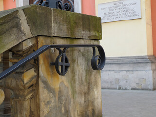 Close-up detail of historic iron mechanism with wheel and gear system mounted on weathered stone...