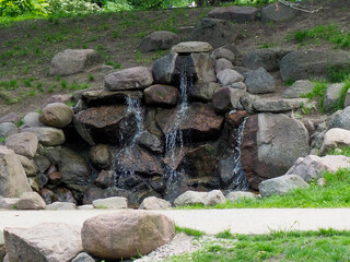 Peaceful stone waterfall feature creating tranquil garden atmosphere in landscaped outdoor space
