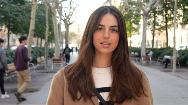 Empowered Young Spanish Woman Walking Confidently on City Street Looking at Camera"