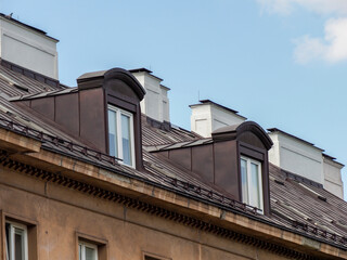 Historic European residential building with mansard windows under blue sky showcasing urban architecture