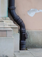 Industrial building drainage system with curved metal pipe and concrete wall detail