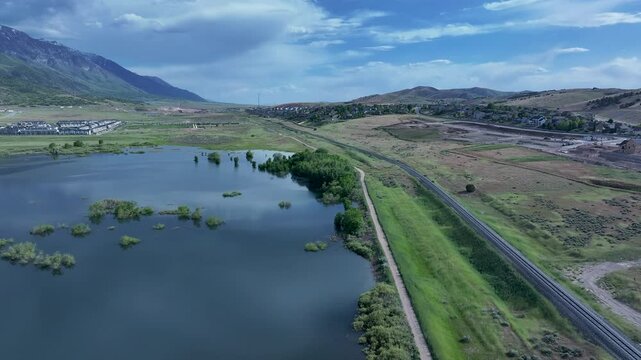 Aerial residential neighborhoods lake Utah mountain valley 2 4K. Orchard, farms and rural ranch property. Lake used for irrigation and recreation. Rural landscape in mountain valley. Agricultural. 