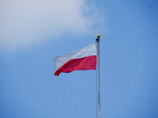 Polish national flag waving proudly against clear blue sky on sunny day