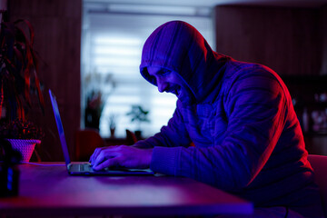 Hacker engaged in intense activity at night in a dimly lit room © Marko