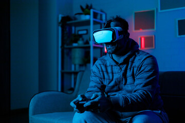 Person using virtual reality headset while gaming in dimly lit room