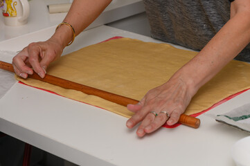 Woman Rolling Out Dough for Homemade Pastries on Floured Surface