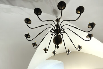 Iron cast wrought chandelier on while ceiling