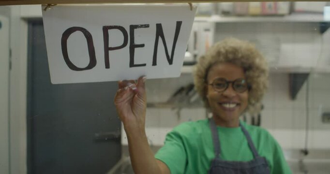 Smiling African Woman with Afro Hair Opening Her Small Restaurant