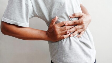 A man touches his waist or back because of pain. Illustration of waist or body pain.