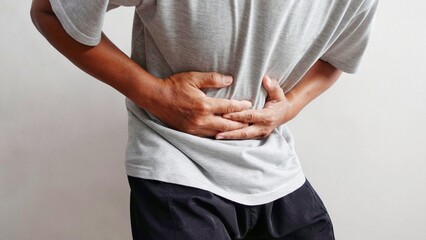 A man holds his stomach in pain. Illustration of stomach or gastric pain.