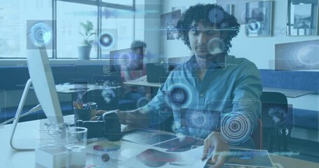 Designer examining printed proofs at desk while activating holographic data widgets for analysis - Powered by Adobe