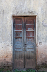 Old wooden door in a wall of an old house in the village