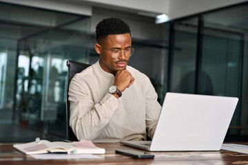 Young male businessman looking at computer thinking on online investment or software technology....