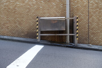 坂道の壁、排気口付近の道路と白い停止線