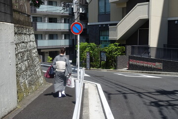 日本の着物を着た女性、荷物を持って急ぐ！