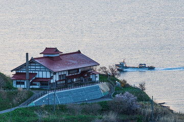 漁船が行く海を見下ろす岬の鰊御殿