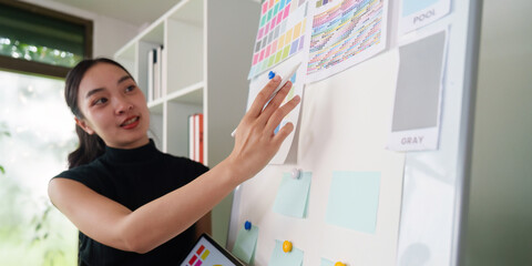 Color Theory and Visual Design. A designer presents ideas on a mood board during a creative meeting.
