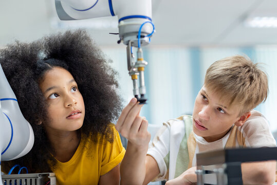 Group Kid teen child enjoy Machine Learning Robot arm is Moving Under coding Control robot at stem technology class, stem education for digital automation learn for use artificial intelligence ai