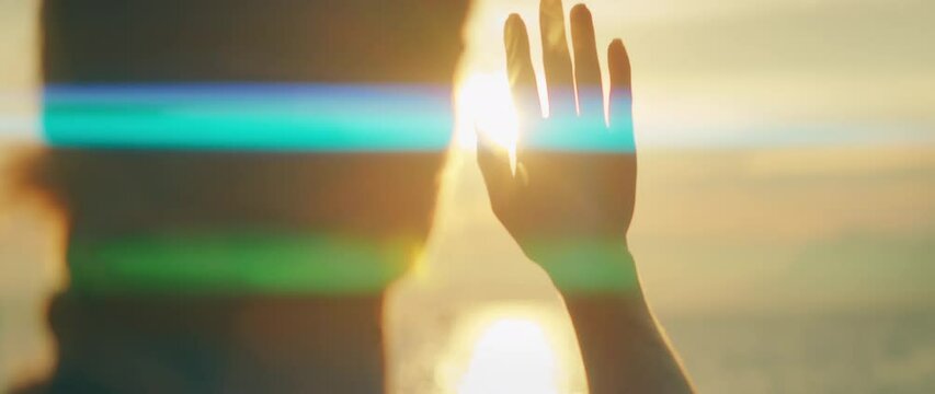 Woman raising hand to block sun while gazing at sea sunset in summer Croatia