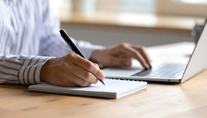 Woman Writing Notes on Notebook Near Laptop