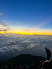 silhouette of man standing on top of mountain