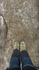 View from above on pair of trekking shoes in a mud